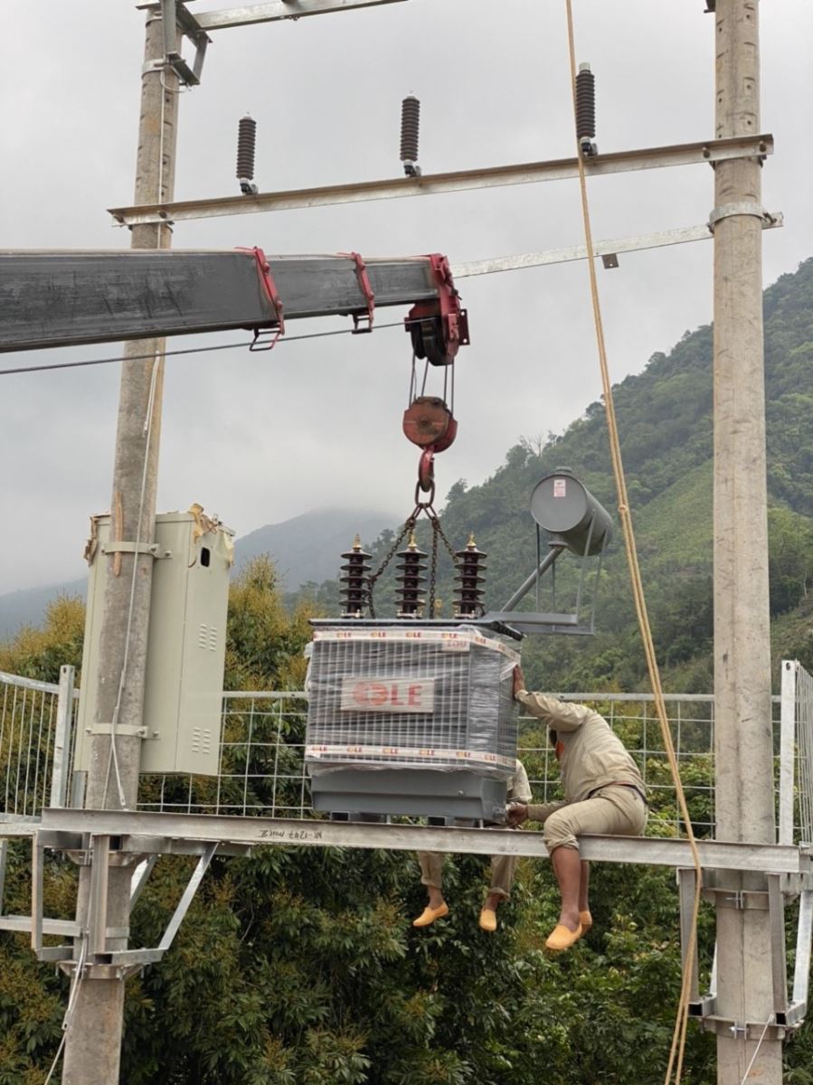 Người thợ điện đang đu mình trên cột để làm việc
